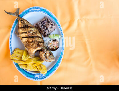 Whole Fish, Rice with Beans and Plantain Chips Stock Photo