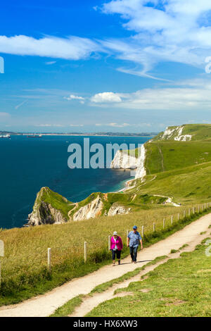 Looking west along the South West Coast Path at walkers near Durdle Door on the Jurassic Coast, Dorset, England Stock Photo