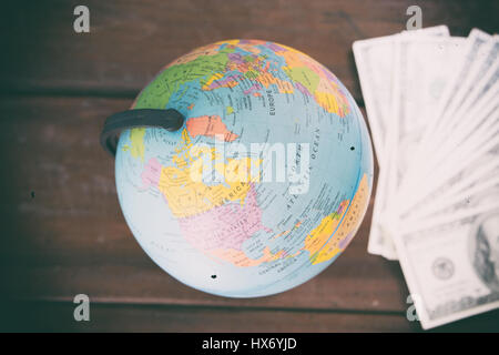 globe with dollar bill on wooden table Stock Photo