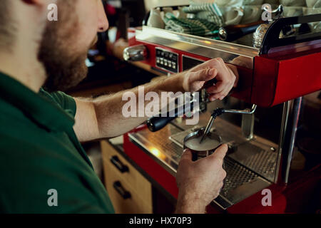 Bartender, barista makes hot milk in a coffee machine behind the Stock Photo