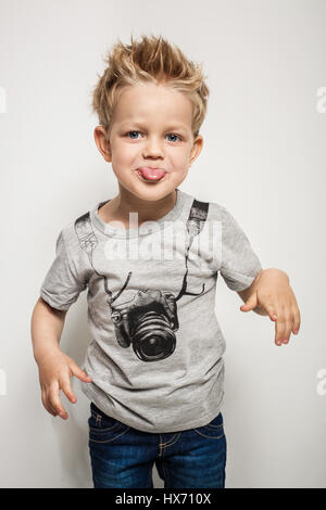 Naughty boy making a grimace and sticking his tongue out. Studio portrait over white background Stock Photo
