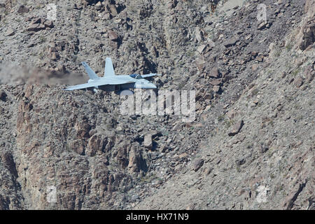United States Navy F/A-18E Super Hornet Flying At Low Level Through A Desert Canyon. Stock Photo