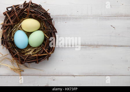 Easter eggs in nest on rustic wooden planks Stock Photo