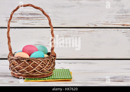 Wicker basket with napkin and Easter eggs isolated on white background ...