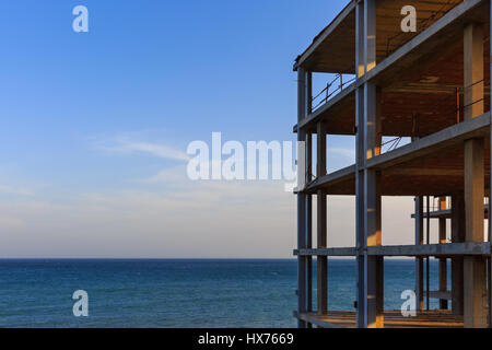 Abandoned skeleton of apartment block on coastal construction site, Costa Blanca, Spain Stock Photo