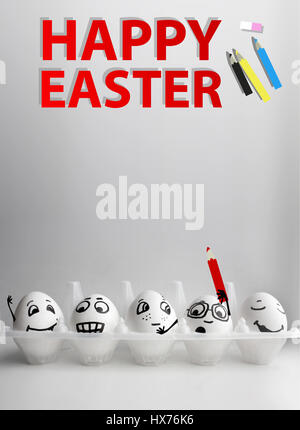 Eggs in a box with faces drawn on a gray background with a pencil Easter inscription to hold in hands. Photo for your design with a place under the te Stock Photo