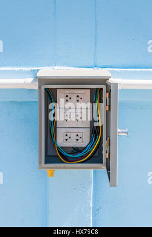 Wrapped White Electric Power Outlet in Gray Cabinet Stock Photo