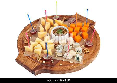 Assorted cheeses on a serving circular board isolated on white background. Stock Photo