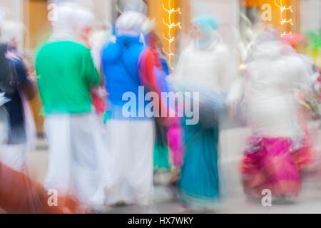 Abstract defocused motion blurred People group of Hare Krishna movement singing and dancing in the streets of the city with the words Hare Krishna Stock Photo