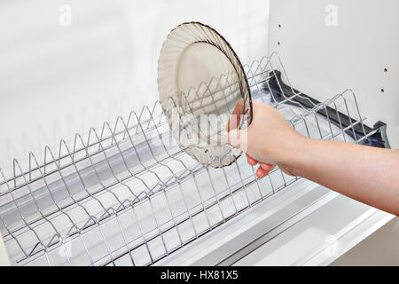 https://l450v.alamy.com/450v/hx81x5/close-up-housewives-hand-takes-a-plate-from-the-wall-kitchen-cabinet-hx81x5.jpg