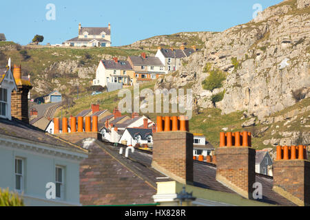 Sunlight from the sunrise across the bay hits the roofs of hotels and B&B's in the popular coastal town of Llandudno, North Wales Stock Photo