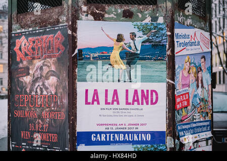 A collection of posters on a public billboard display in Vienna, Austria featuring the movie La La Land with Emma Stone and Ryan Gosling. Stock Photo