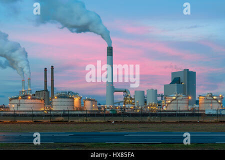 Smoke emission from factory pipes of oil refinery in night, Netherlands. Emission environment from oil refinery. Stock Photo