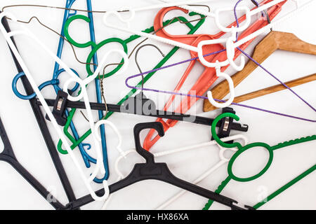 Many hangers of different shapes and colors, top view, white background. Stock Photo