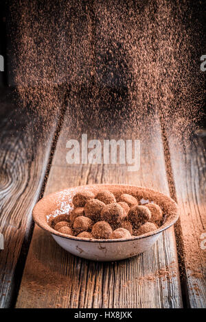 Sweet chocolate balls in white bowl and cocoa powder Stock Photo
