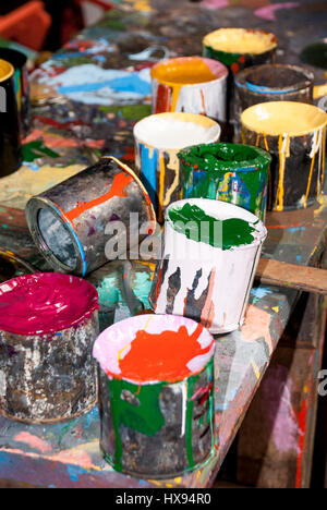 Paint bottles, brushes and paint cans in an art studio Stock Photo