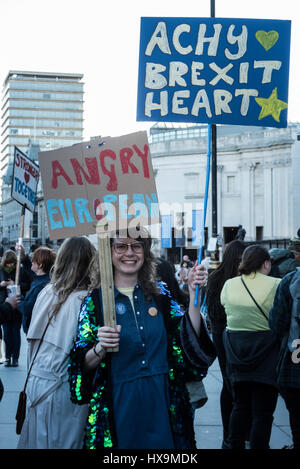 A happy, peaceful protestor in front of the National Gallery (Trafalgar Square) holding two signs at once during the United for Europe March in London, UK on the 25th of March 2017. Credit: Hannah Alexa Geller/Alamy Live News Stock Photo