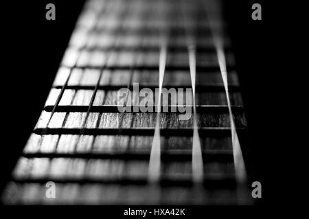 Concert music instrument guitar strings in black white silver. Closeup of the string instrument for classic rock pop isolated on black background. Stock Photo