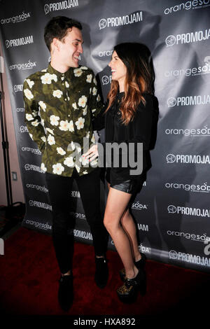 Shenae Grimes (r) and husband Josh Beech kissing the red carpet at the