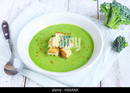 Homemade spicy broccoli cream soup with croutons in white bowl - healthy green vegetarian vegan detox diet homemade fresh soup food Stock Photo