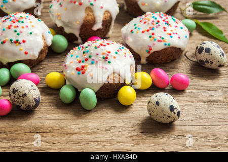 Easter pastry. Fresh Homemade Carrot Mini Cakes with White Creamy Sugar Icing and Colorful Decor over wooden background with copy space. Easter Cakes  Stock Photo