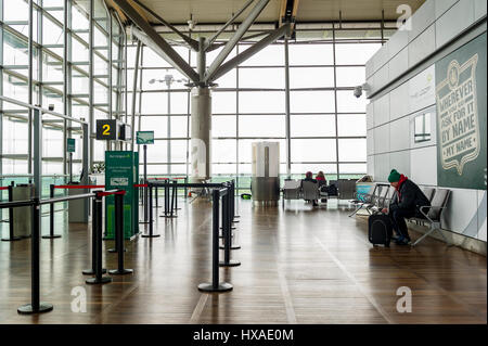 Birmingham Airport's (BHX), United Kingdom departure lounge with a man sitting on his own waiting to board a flight. Stock Photo