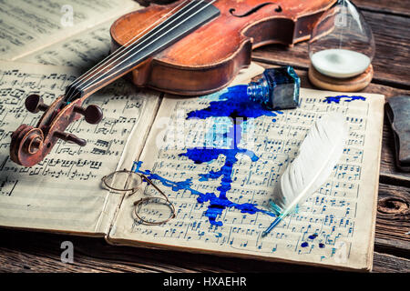 Old sheets and violin on old wooden table Stock Photo