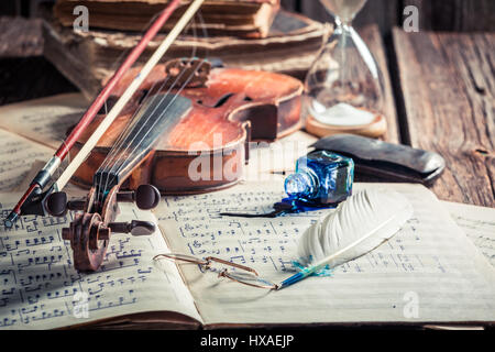 Retro sheets and violin on old wooden table Stock Photo