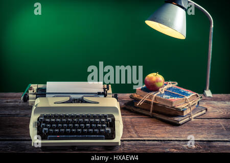 Lamp and typewriter in the classroom on old wooden table Stock Photo