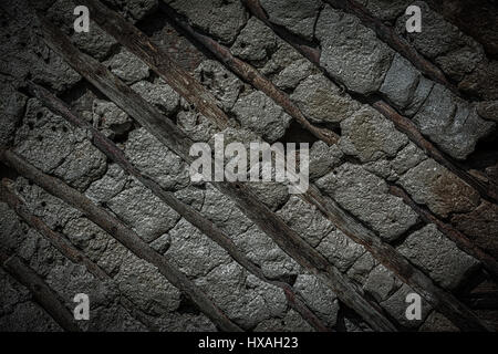 Old stone and wood wall texture background. Vintage dark toned Stock Photo