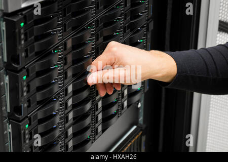 IT Engineer's Hand Replacing Hard Drive In Data Center Stock Photo