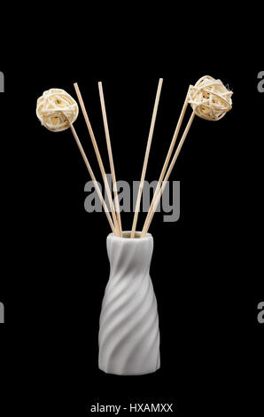Decorative ceramic vase with wooden chopsticks on a black background Stock Photo