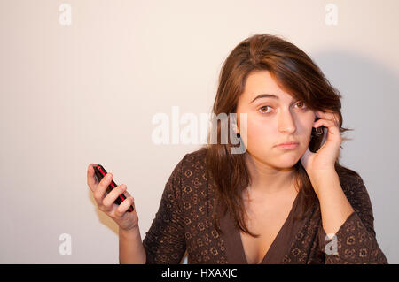 Young woman using two mobile phones. Stock Photo