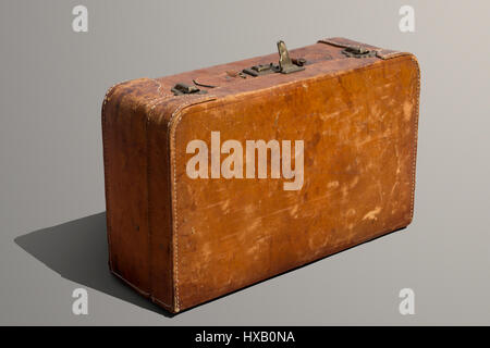 Dusty and scratched old leather standing suitcase Stock Photo