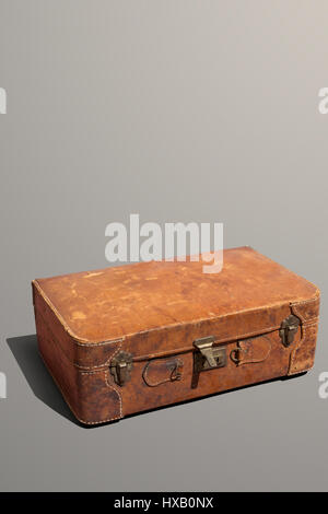 Dusty and scratched old leather suitcase laying down Stock Photo