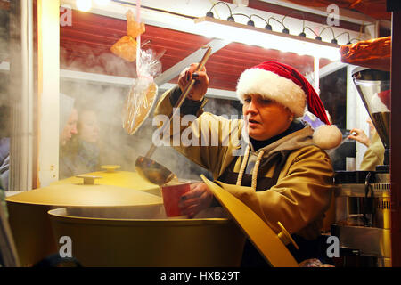 KYIV, UKRAINE - DECEMBER 20, 2015: Woman sell mulled wine at traditional Christmas market on Sophia Square in Kyiv Stock Photo