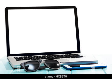 Work on the go. Modern laptop computer with smartphone and sunglasses on blue table Stock Photo