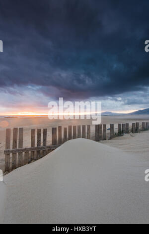dramatic sunset and storm clouds over beach in Tarifa, Spain famous surf spot known for its winds. Stock Photo