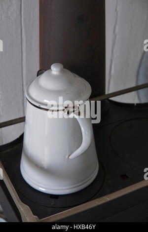 Antiqe Enamel Coffee Pot on Woodstove Stock Photo