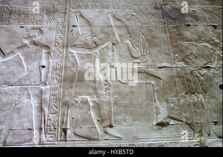 Pharaoh Seti l holds out a censer to Osiris at Abydos Temple Stock Photo
