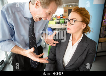 Angry boss screaming at workers Stock Photo