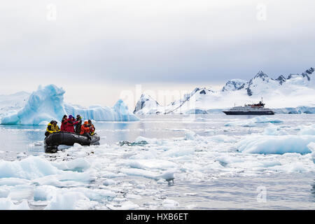 Antarctica tourists in Zodiac among Antarctic iceberg.