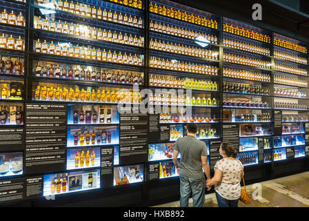 Visitors viewing the Wall of Bundy - a history of Bundaberg Rum products.  Bundaberg, Queensland, Australia Stock Photo