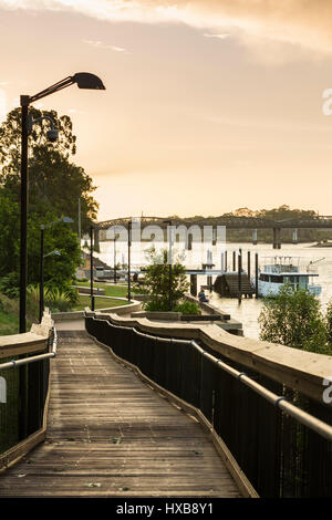View along the riverside walkway at sunset with the Burnett Bridge in the distance.  Bundaberg, Queensland, Australia Stock Photo