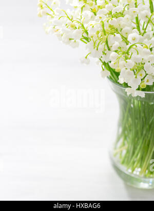 Bouquet of Lilies of the Valley in glass vase. Stock Photo