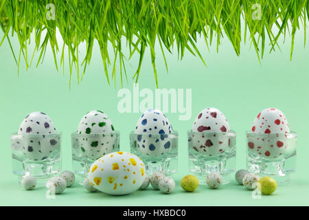Easter egg in glass cups on green background Stock Photo