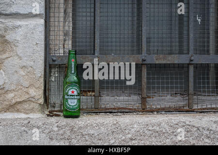 Empty Heineken beer bottle left on the street Stock Photo