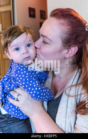 Mother kissing her three month old baby girl Stock Photo