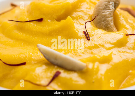 hapus or alphonso Mango pudding / Mango shrikhand or srikhand or amrakhand - Mango dessert with condensed milk magoes and nuts, selective focus over w Stock Photo