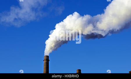 Factory plant smoke stack over blue sky background Stock Photo
